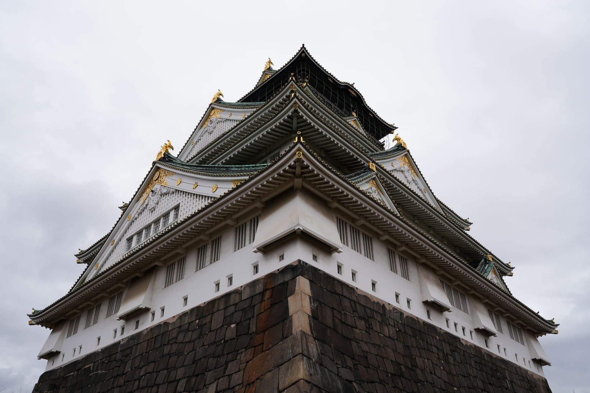 Le donjon blanc et vert du château d'Osaka dominant les remparts et les douves