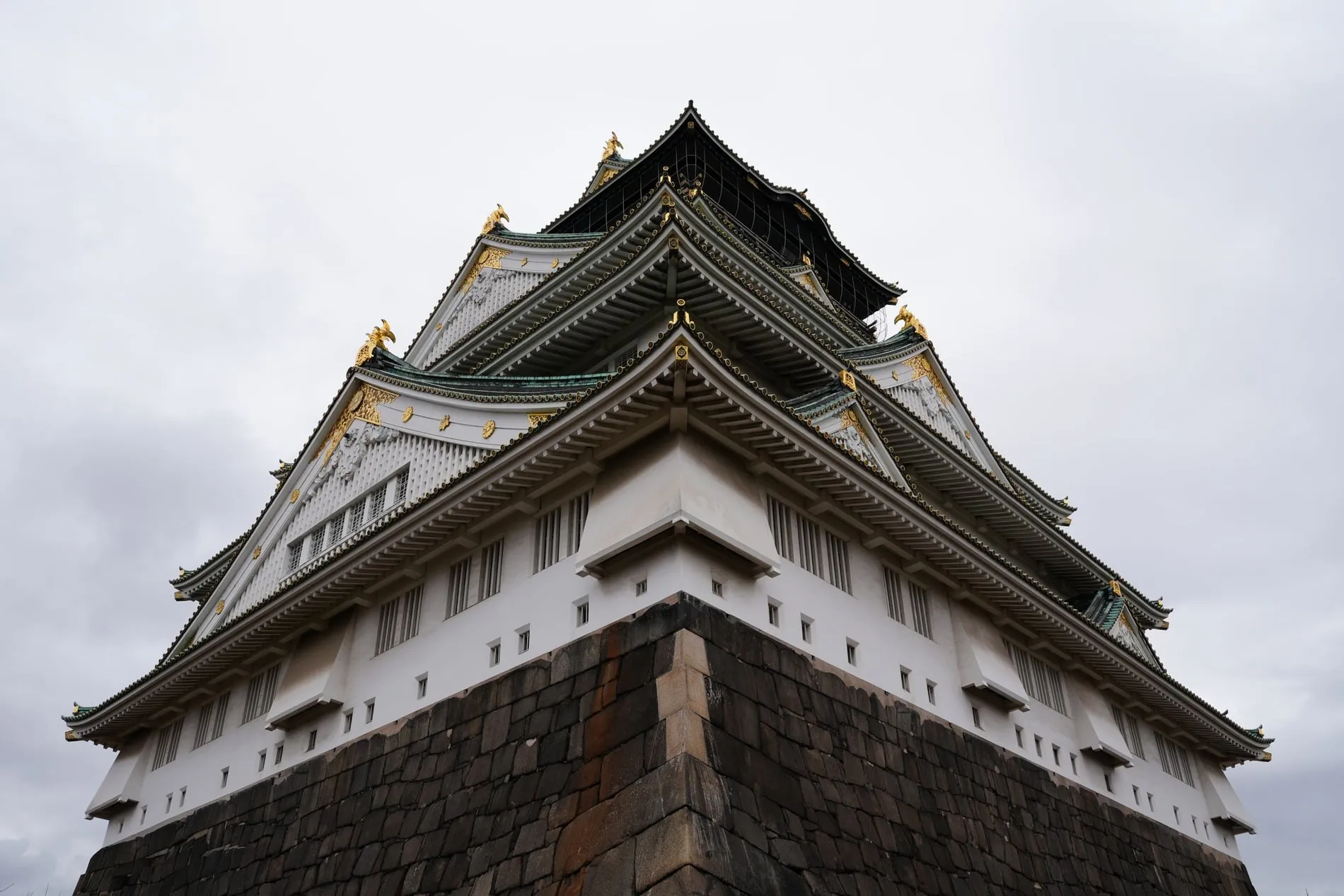Le donjon blanc et vert du château d'Osaka dominant les remparts et les douves